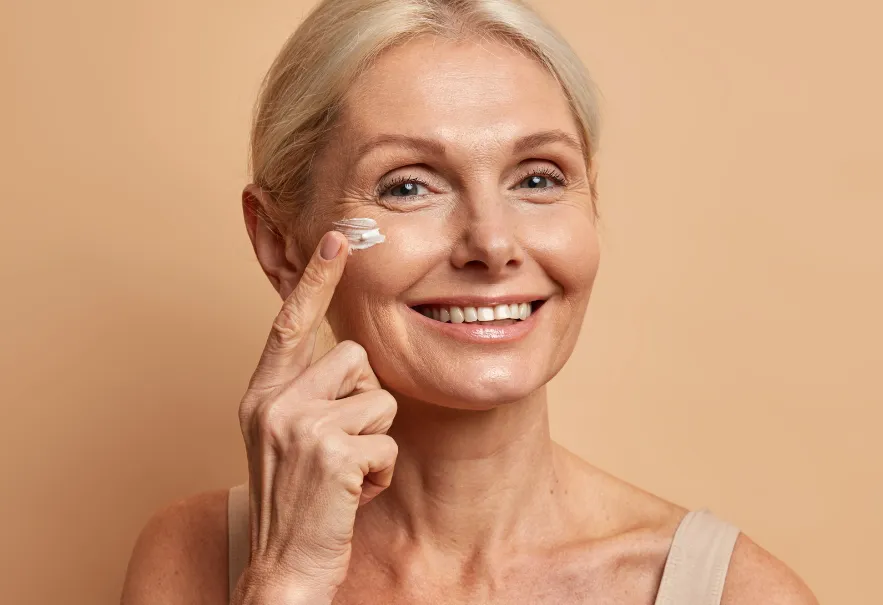Mature woman using PDRN face cream for wrinkles and fine lines