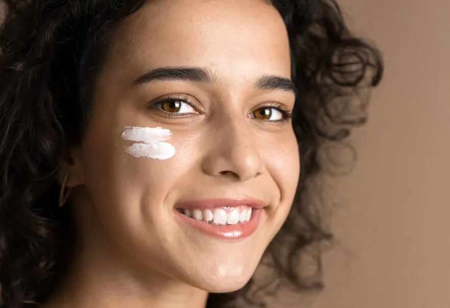 Teenage girl using face cream for skin acne